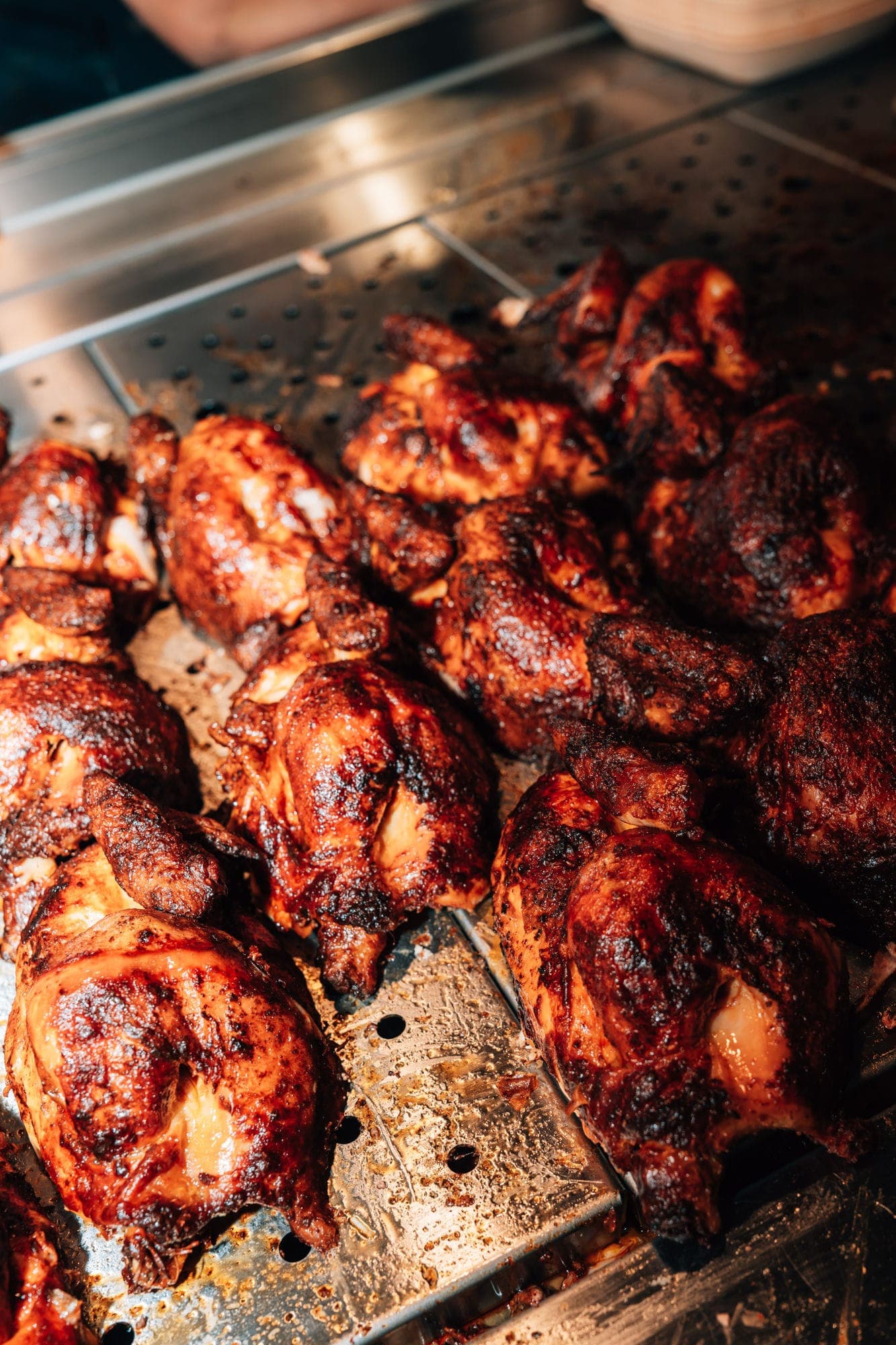Frisch gegrillte halbe Hähnchen auf dem Blech bei Nhas City Chicken