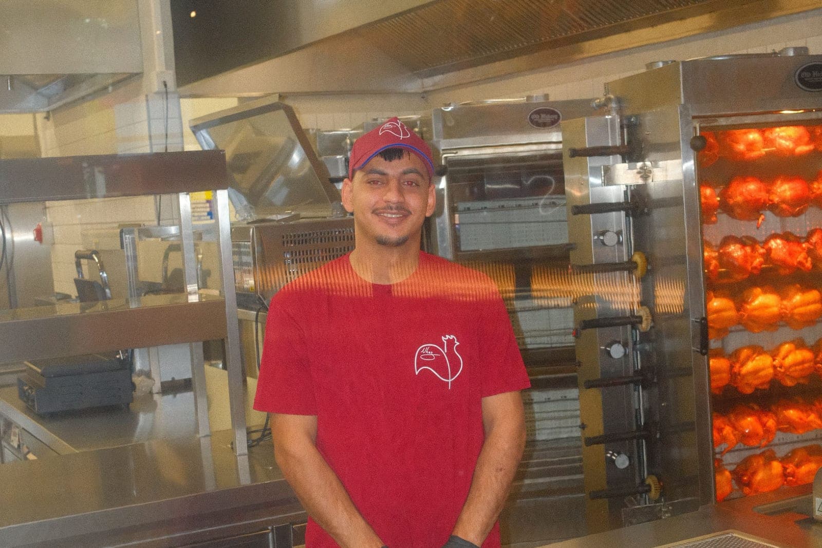Mitarbeiter vor dem Hähnchengrill im neuen Kölner Store von Nhas City Chicken
